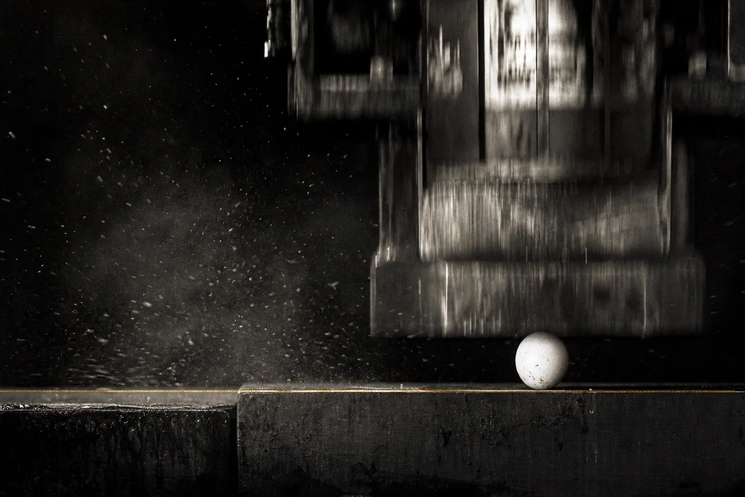 An industrial press stopping above a fragile egg